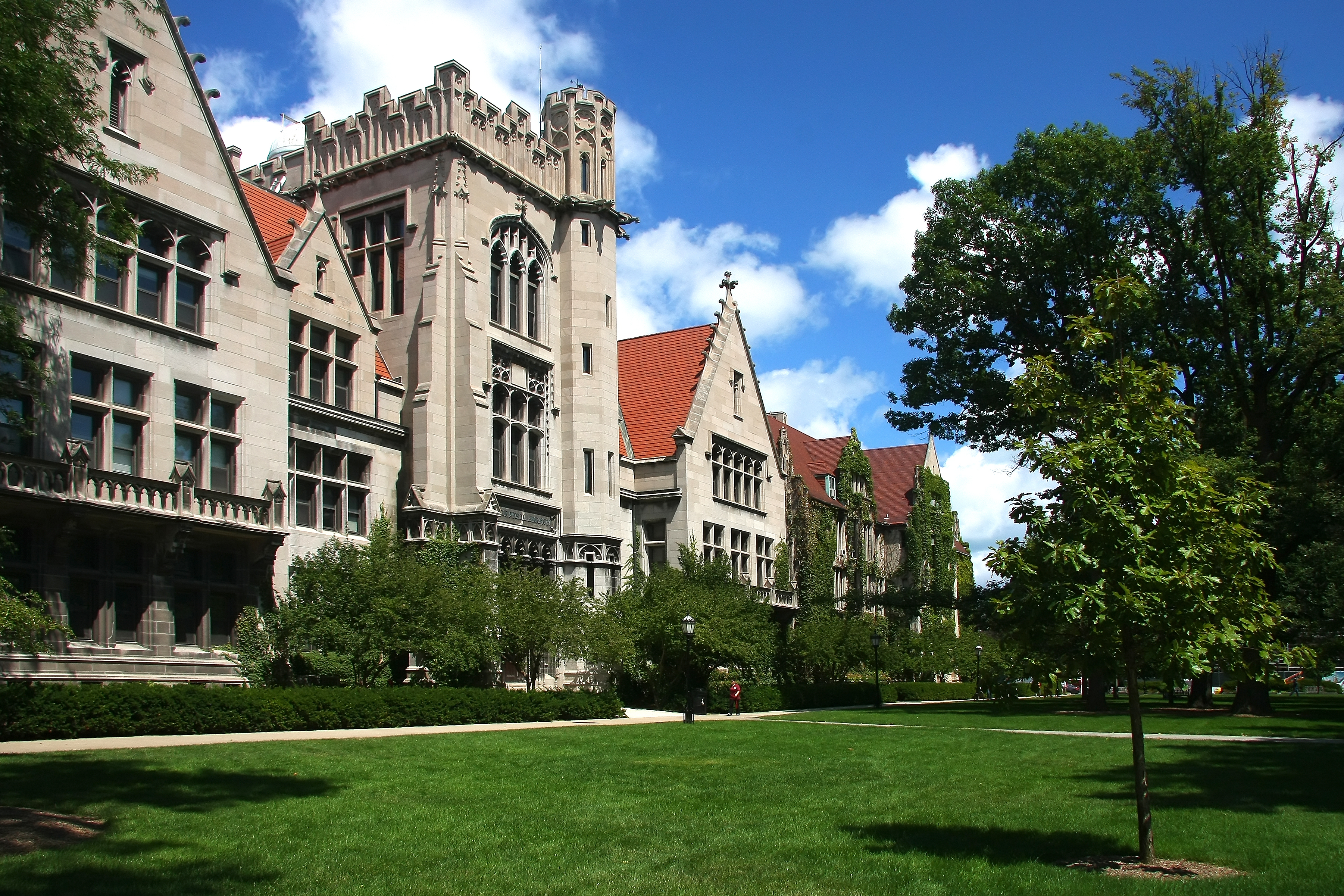 "University building with red roofs and green lawn on campus"
